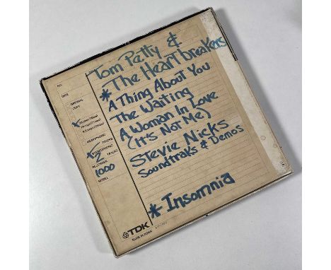 A reel of TDK 1/4" recording tape with handwritten info to box documenting contents as being recording by Tom Petty and the H