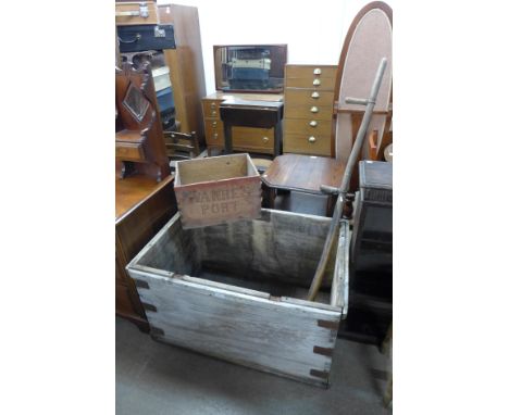 A large pine trunk (lacking lid), a pine box and a scythe 