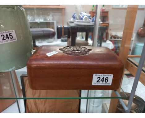 A carved teak box with Royal Army Ordnance Corps emblem and contents of military buttons and badges