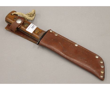 An army survival  knife in a leather sheath. 33 cm long overall.