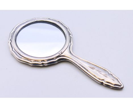 A silver small hand mirror.  12.5 cm high. 