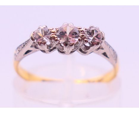 An 18 ct gold and platinum three stone diamond ring. Ring size K/L.