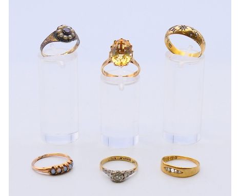 Three 18 ct gold rings 6.9 grammes total weight, a 9 ct gold ring and two unmarked rings.7.6 grammes total weight. 