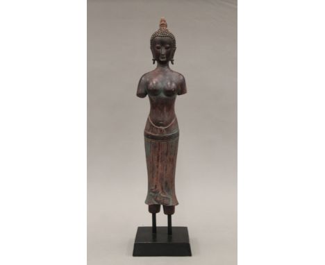 A Far Eastern model of a female deity on a stand. 45.5 cm high overall.