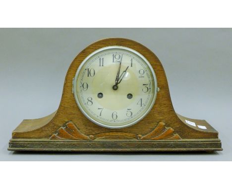 An oak wall clock, another wall clock  and an oak mantle clock. The former 64 cm high.