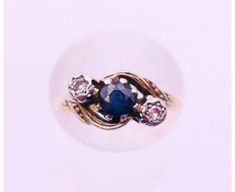 An 18 ct gold, diamond and sapphire three-stone ring. Ring size I.