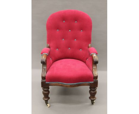 An button-upholstered Victorian mahogany open armchair. 62 cm wide.