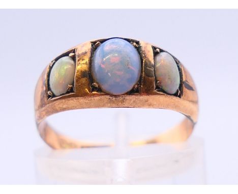 A 9 ct gold three-stone opal ring. Ring size L/M.