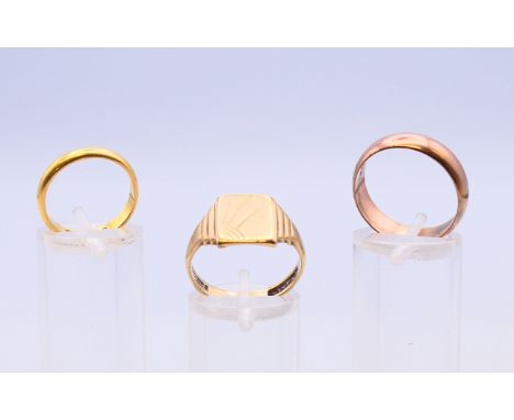 A 22 ct gold wedding band 3.8 grammes, a 9 ct gold wedding band and a 9 ct gold signet ring 8.3 grammes.