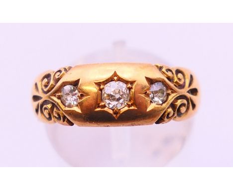 An 18 ct gold three stone gypsy set ring. Ring size O.