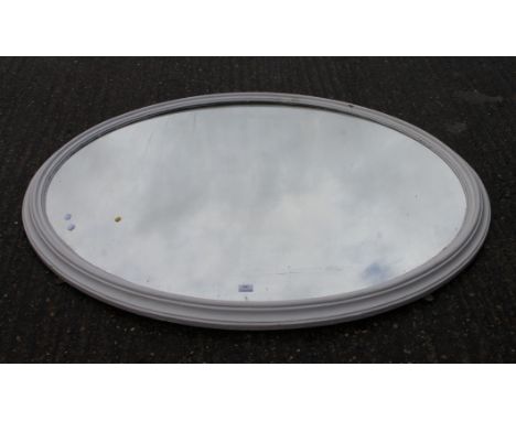 A large white painted Victorian oval mirror. 143 cm wide.
