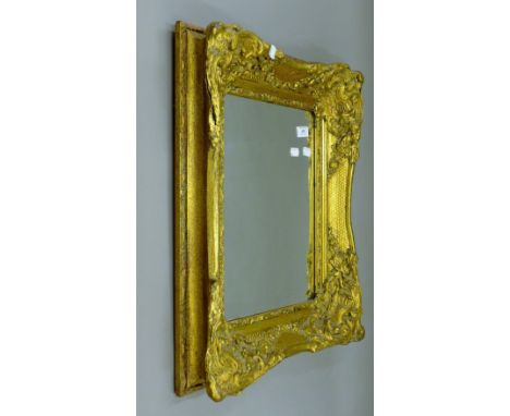A wall mirror in a large ornate gilt frame 49 x 59 cm overall.