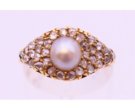 An unmarked gold diamond and pearl ring. Ring size O.