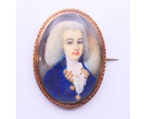 An 18th century miniature portrait on ivory of a young gentleman wearing a powdered wig set in a gold brooch.  4.5 cm high. N