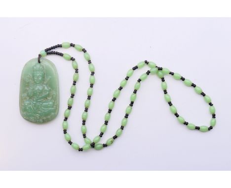 A Chinese jade pendant on a green and black bead necklace.  Pendant 6 cm high, necklace 62 cm long. 