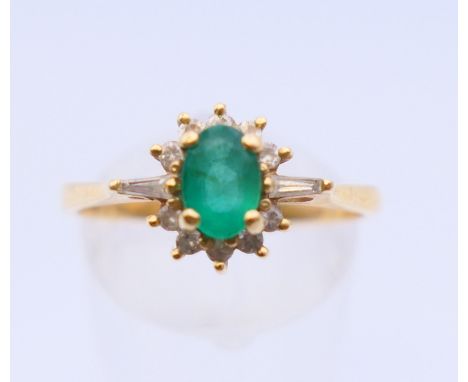 An 18 ct gold, diamond and emerald ring. Ring size R/S.