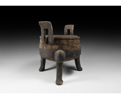 Han Dynasty, 206 BC-220 AD. A ceramic blackware ding ritual vessel with drum-shaped body, three splayed legs, two square hand