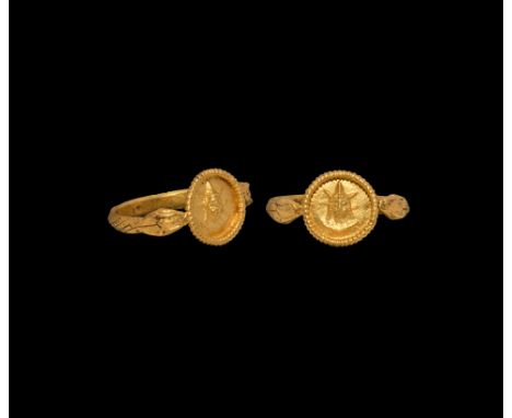 3rd century AD. A gold finger ring with snake-head shoulders and hatched outer face to the hoop, disc bezel with beaded wire 