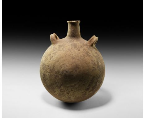 2nd-1st millennium BC. A substantial ceramic flask with discoid body, short flared spout and two gusseted loop handles to the