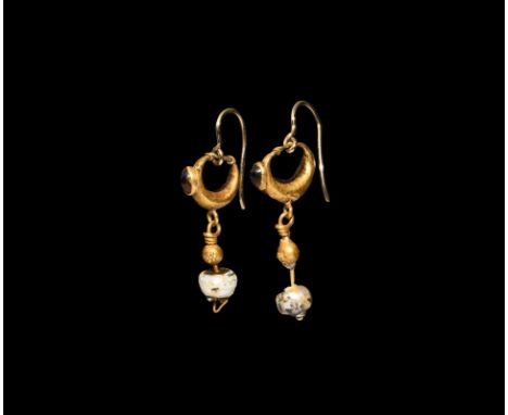 2nd-4th century AD. A matching pair of gold hollow-form crescentic earrings with a garnet in a cell to the forward face, a lo