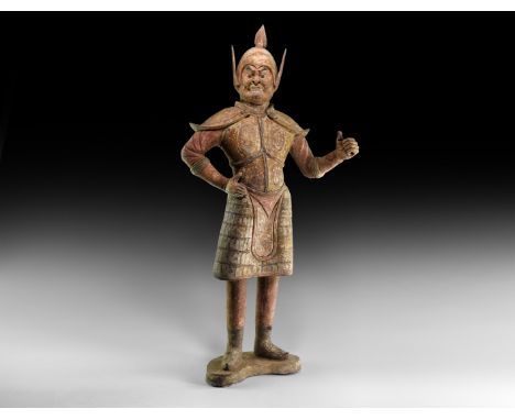 Tang Dynasty, 618-906 AD. A substantial ceramic figure of a guard standing on a crescent base, wearing a domed helmet with sp