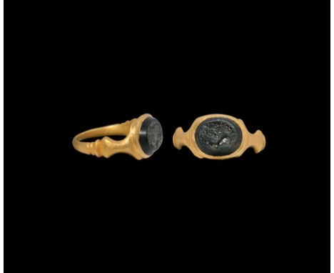 2nd-3rd century AD. An agate cloison, intaglio dolphin, prawn and fish, set into a later gold finger ring with trumpet-shaped