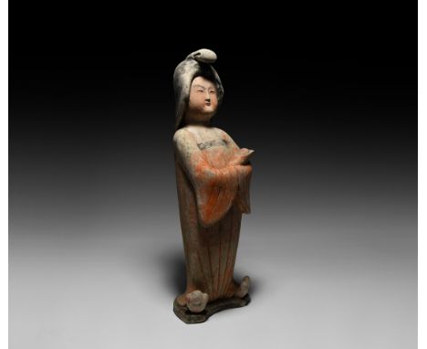 Tang Dynasty, 618-906 AD. A hollow-formed ceramic figure of a courtly lady standing wearing floor-length robe with cloud slip