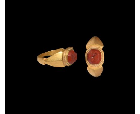 3rd century AD. A red jasper gemstone, intaglio dolphin and anchor motif, set into a later gold ring with facetted hoop, hear