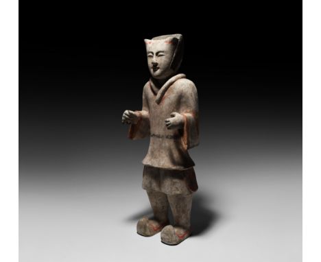 Han Dynasty, 206 BC-220 AD. A ceramic standing figure of a guard wearing tunic, trousers and boots with curled toes; the arms