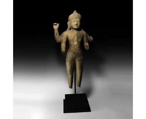 11th-13th century AD. A carved sandstone guardian figure (yaksha) standing, wearing a belted sampot and conical makuta headdr