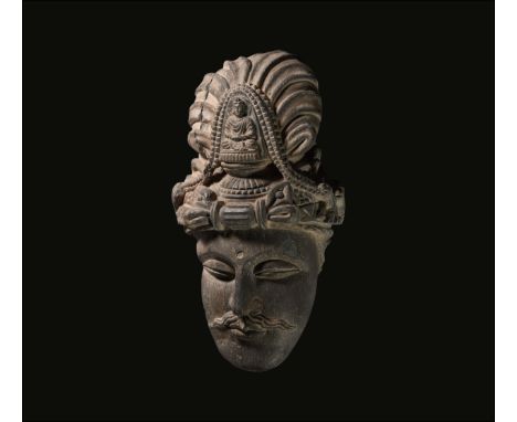 2nd-3rd century AD. A carved schist head of Buddha in three-quarter view with crested turban and socket to the brow to accept