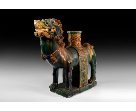 Ming Dynasty, 1368-1644 AD. A ceramic figure of a lion on a rectangular base with deep green glaze, chestnut-brown detailing 