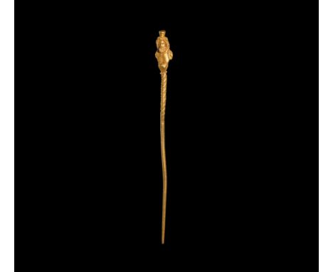 1st-2nd century AD. An elaborate gold stylus or pin with Serapis, the god of fertility; the upper end of the tapering pin twi