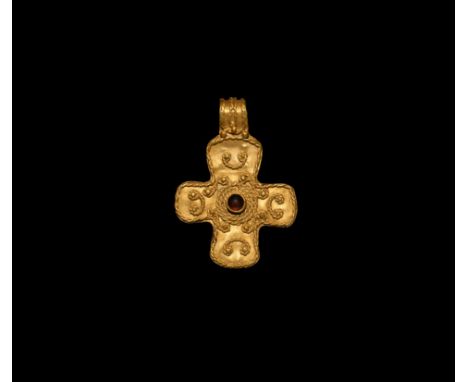 5th-7th century AD. A gold equal-arm cross pendant with applied central garnet cabochon, the outer edges framed with applied 