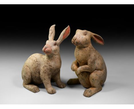 Han Dynasty, 206 BC-220 AD. A pair of ceramic rabbit figures in dynamic poses, each with painted detailing to the eyes, nose 