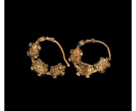 8th-10th century AD. A matched pair of gold ear- or temple-rings, each a substantial hoop with three hollow bulbs and a disco