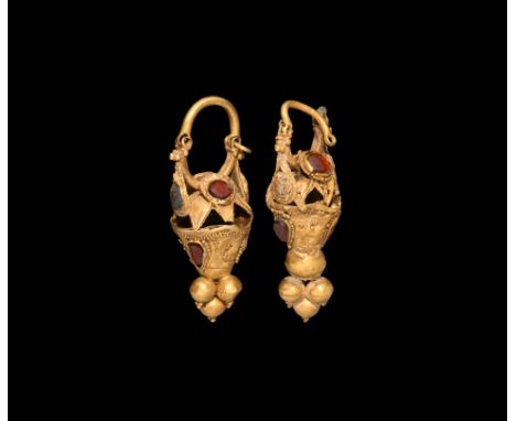2nd century BC-2nd century AD. A matched pair of gold earrings, each a hoop with hinged closure, biconvex body with cells wit