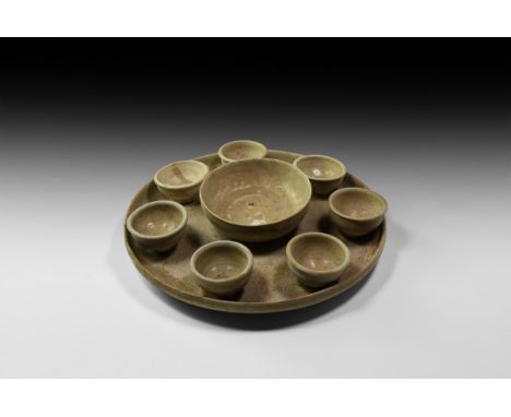 Song Dynasty, 960-1127 AD. A ceramic table set in cream to olive glaze, comprising a shallow footed tray with low rim, centra