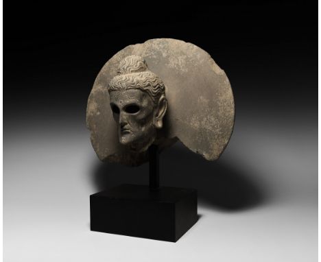 2nd-4th century AD.&nbsp;A schist statue fragment with bust of Buddha with large aureole behind the head, emaciated face with