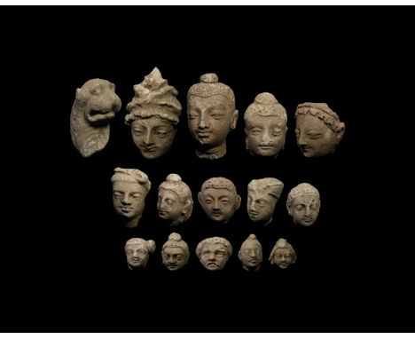 2nd-4th century AD. A group of fifteen stucco human and animal heads of various sizes, comprising: a dog's head; buddha heads