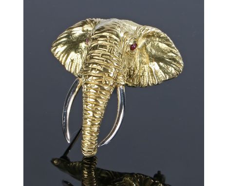 18 carat gold elephant head brooch, set with ruby eyes with a arched trunk and long white gold tusks, 22.3 grams, 45mm long