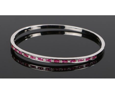 18 carat gold ruby and diamond bangle, set with square cut rubies and diamonds, 66mm diameter, 14.7 grams