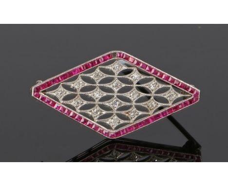 Art Deco diamond and ruby brooch, the fret diamond set brooch with a ruby surround set to white metal