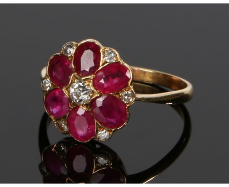Diamond and ruby set ring, in the form of a flower head set with a central diamond and ruby petals, ring size P