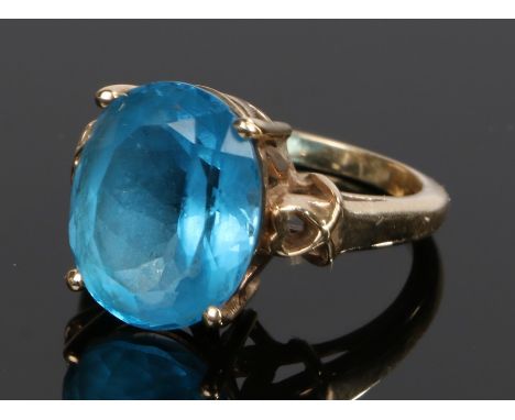 9 carat gold blue topaz ring, the oval topaz flanked by pierced shoulders, ring size O, 7g