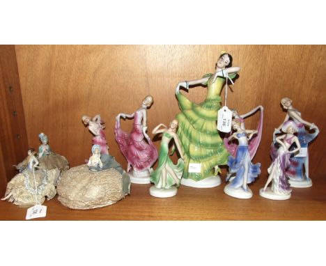 Three ceramic crinoline lady pin cushions and eight Continental ceramic female figure ornaments, (11).