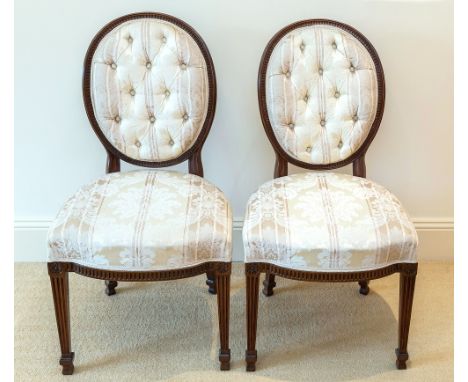 A pair of Hepplewhite style side chairs, late Victorian, oval framed flute show frame backs with deep button backed upholster