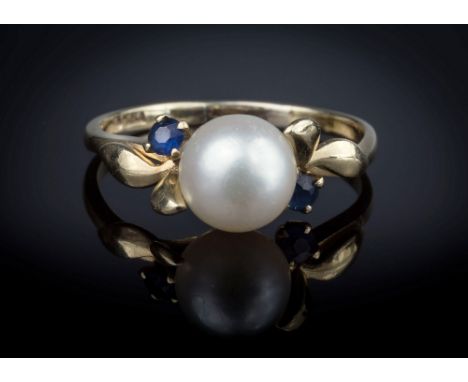 A 14ct yellow gold, cultured pearl and sapphire twist ring, the single 7mm. pearl flanked by two round cut sapphires and pair