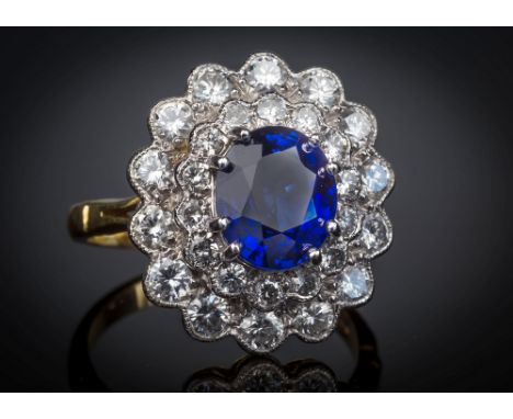 An 18ct yellow gold, sapphire and diamond cluster ring, the 2.53ct oval cut sapphire of good colour, within a millegrain flor