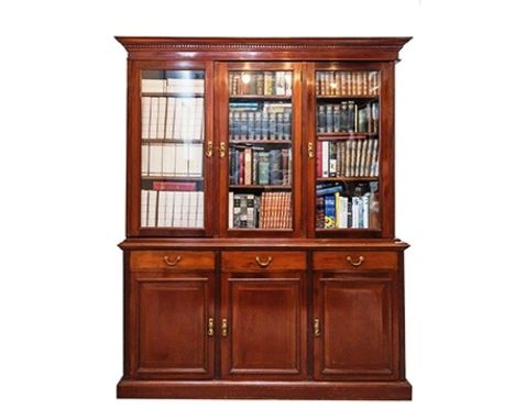 A late Victorian mahogany library bookcase, the flared, ogee and dentil carved cornice over three glazed doors enclosing nine